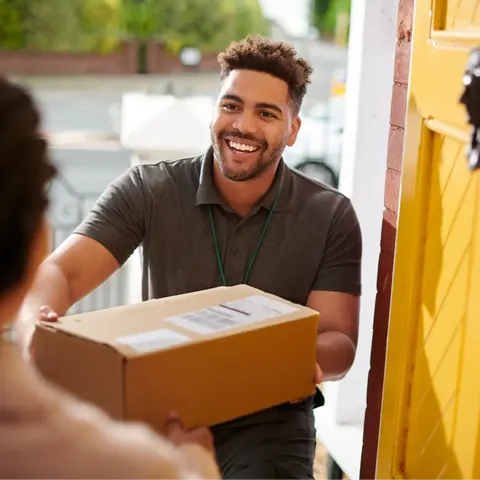 Courier handing a package to a customer at the door